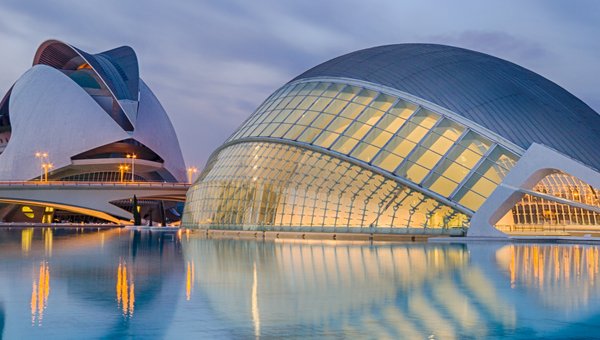 Un bâtiment moderne devant une grande piscine.