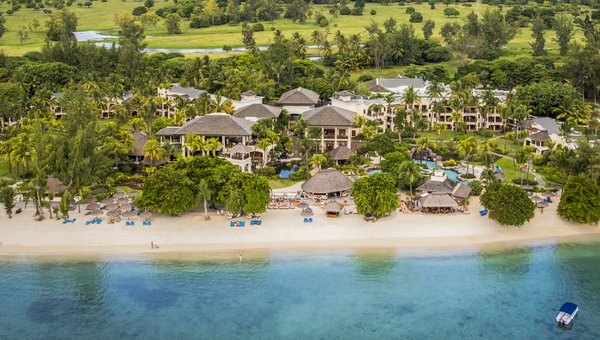 Ein Sandstrand mit Meer und im Hintergrund markante Hügel