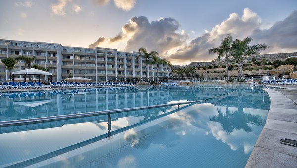 Seabank Resort & Spa, Mellieha, grande piscine avec palmiers et hôtel en arrière-plan