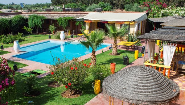 Handioasis Marrakesch, farbenprächtiger Innenhof mit Blumen, Palmen und Pool