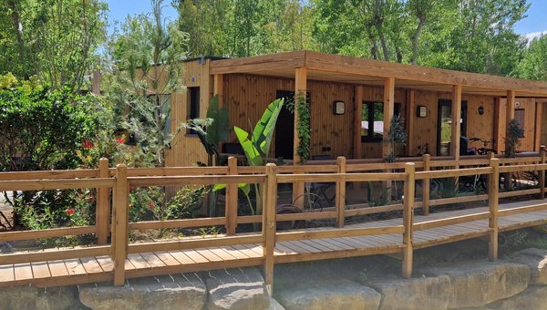 Blick auf die Mobilhomes aus Holz im Hintergrund sieht man Bäume