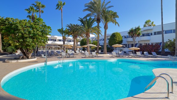 Sicht auf die Poolanlage mit Poollift, Liegestühlen mit Schatten von Palmen